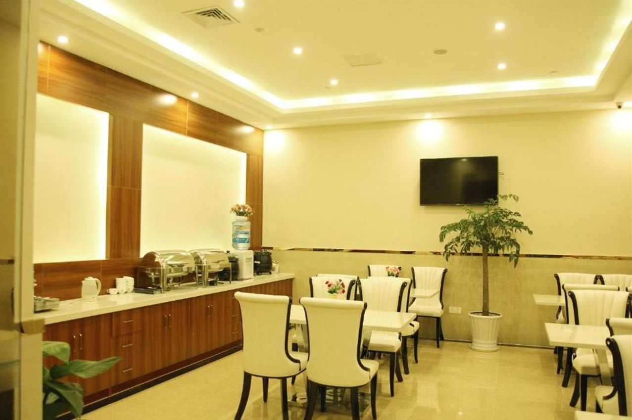 A hotel lobby with a reception desk, seating area, and a TV mounted on the wall.