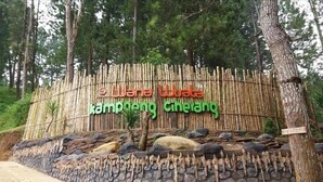 A bamboo fence with a sign that reads "Wana Wuta" and "Kampong Cirelang" in front of a natural setting with trees and rocks. - OYO 2922 Wisma Kampoeng Ciherang Syariah (Sumedang)