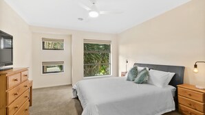 A bedroom with a bed, a TV on a dresser, and two windows. - Ocean View Crescent 59 Torquay Pet Friendly (TORQUAY)