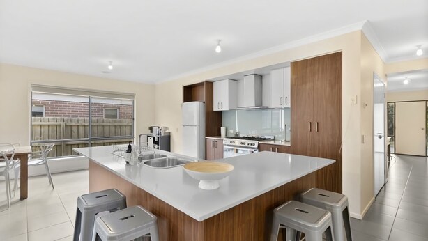 A modern kitchen with a central island, stainless steel appliances, and a view to the outside. - Ocean View Crescent 59 Torquay Pet Friendly (TORQUAY)