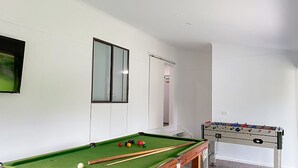 A room with a pool table, a foosball table, and a door leading to another room. - Immaculately prepared property is only 40 metres from the foreshore (TORQUAY)