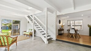 A modern interior with a staircase, a dining area, and a living space with a view to the outdoors. - Puebla Casa 17  Walk to Beach & Shops (TORQUAY)