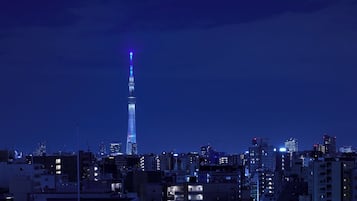 A cityscape with a prominent tower lit up in blue.