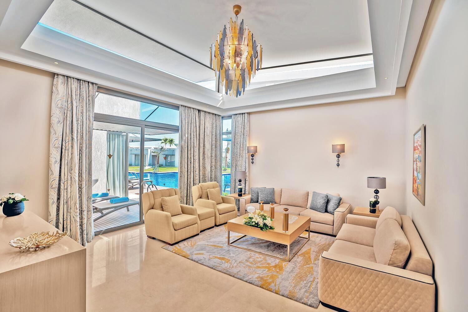 A modern living room with a sofa set, a coffee table, and a chandelier.