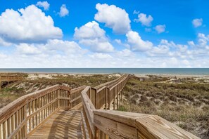 Walk along the boardwalk to the beach, where the sand and dunes await.