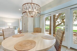 Enjoy meals in a cozy dining area with a round table for four, featuring woven placemats and a chandelier.