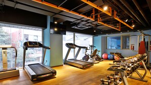 Una sala de gimnàstica amb cintes de córrer, màquines el·líptiques i equips de musculació.