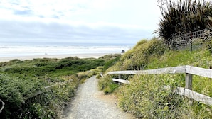 A gravel path leading to a beach with a wooden fence on one side. - Ocean view, 100 yards to beach, pet friendly, secure fenced yard. (Bandon)