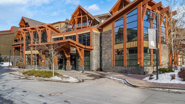 A modern building with a reception area, large windows, and a stone facade. -  Mountain Luxury Resort (Canmore)