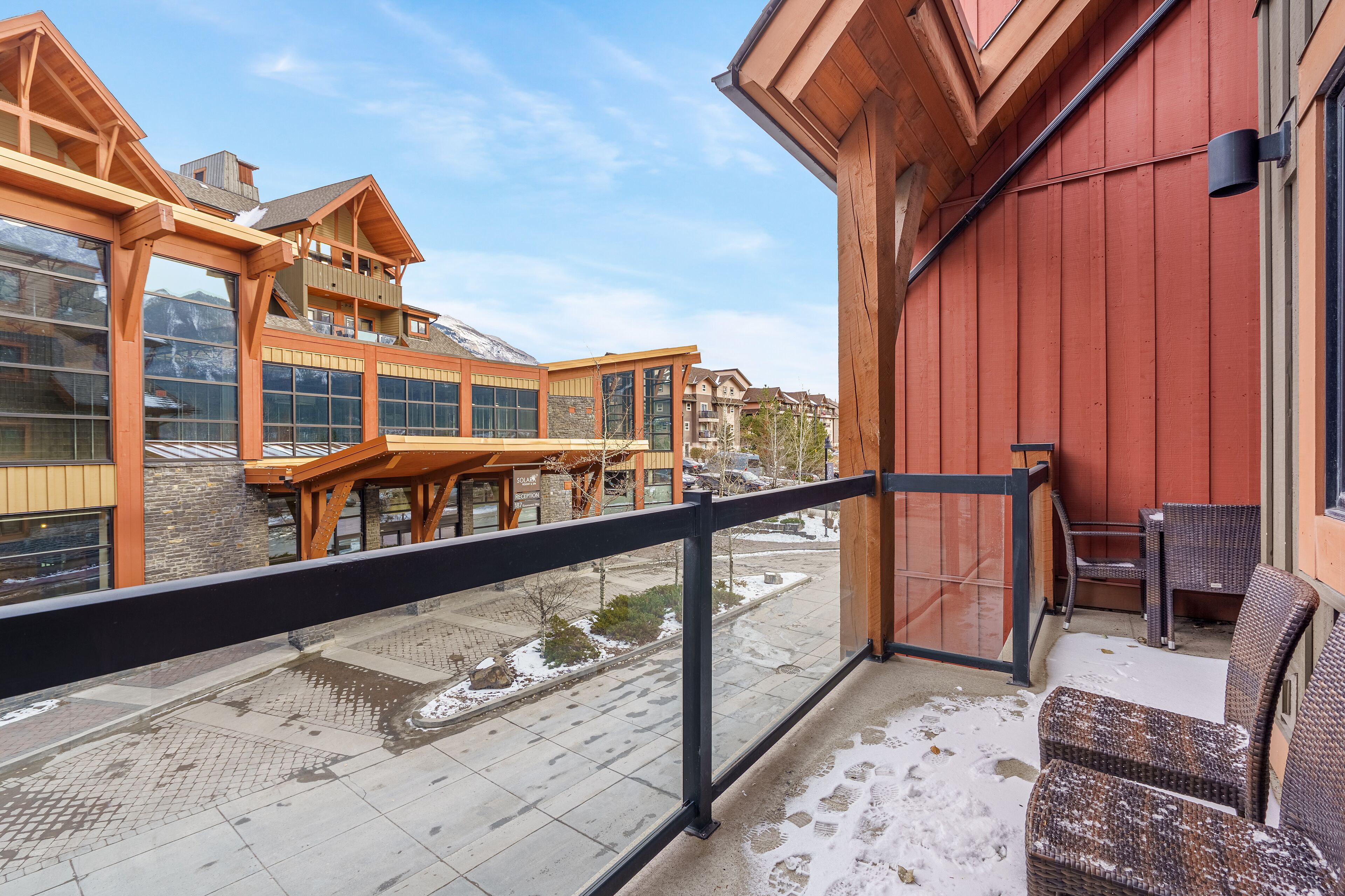 A hotel reception area with a wooden balcony overlooking a snowy street.