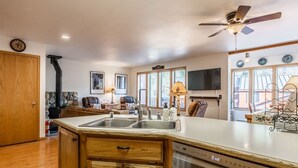 A modern kitchen with wooden cabinets, a dishwasher, and a large island with a sink. - Aspen Meadows #2 Sun-Filled, 3 bedroom condo (June Lake)