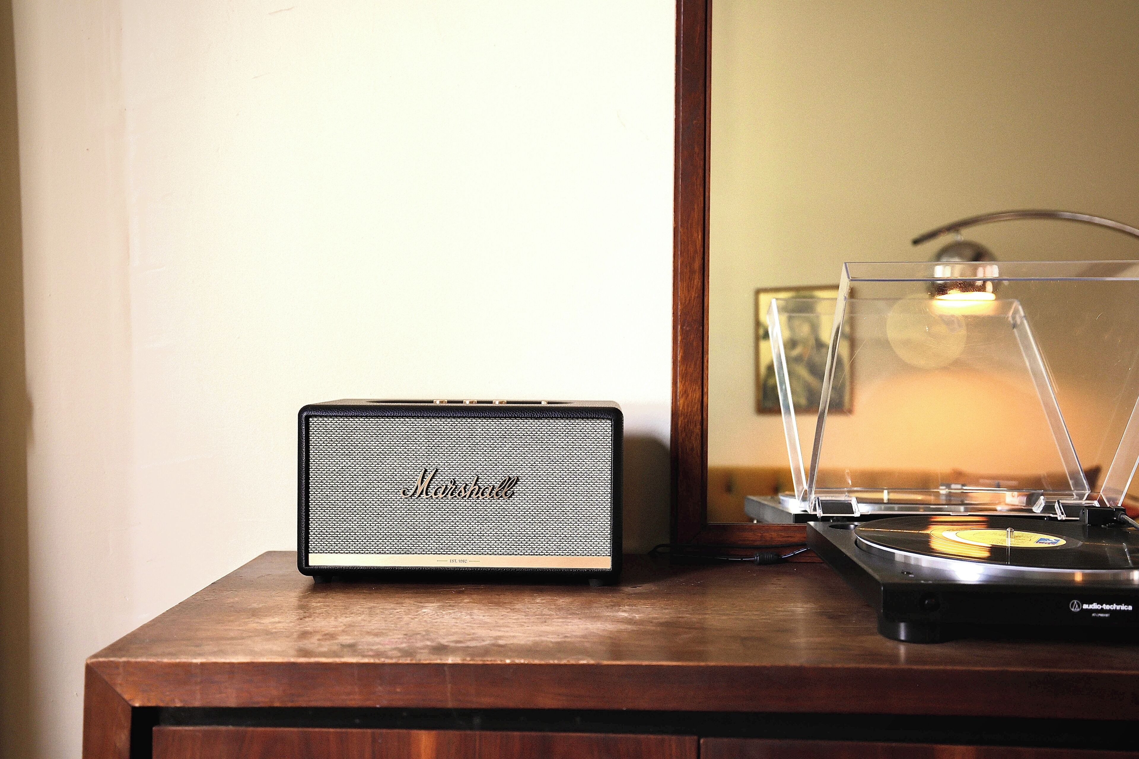 A Marshall speaker and a turntable on a wooden surface.