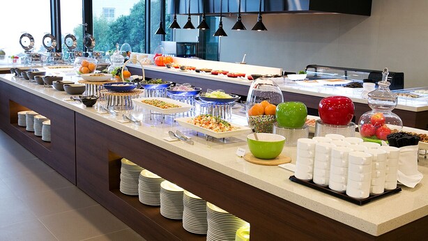 Un buffet proposant une variété de plats et d'ustensiles.