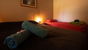 Una habitación de hotel con una cama, una mesita de noche, una lámpara y un cuadro en la pared.