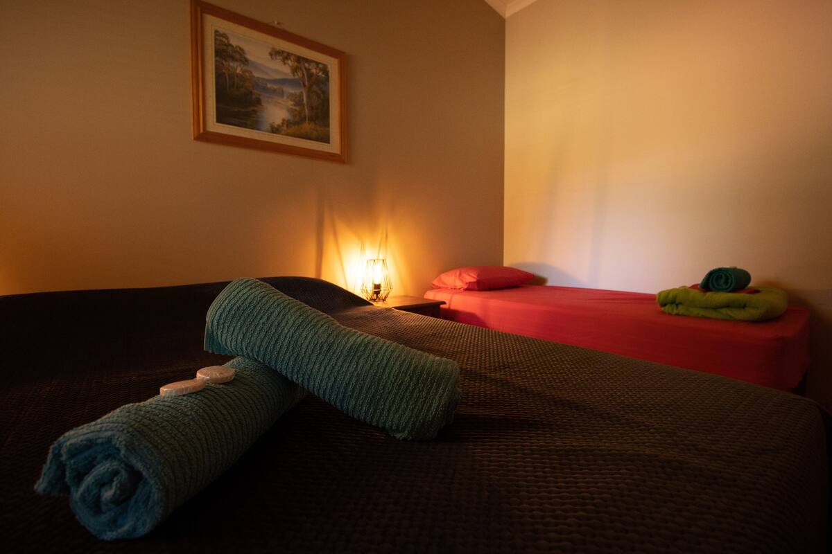 Une chambre d’h ôtel avec un lit, une table de chevet, une lampe et un tableau au mur.