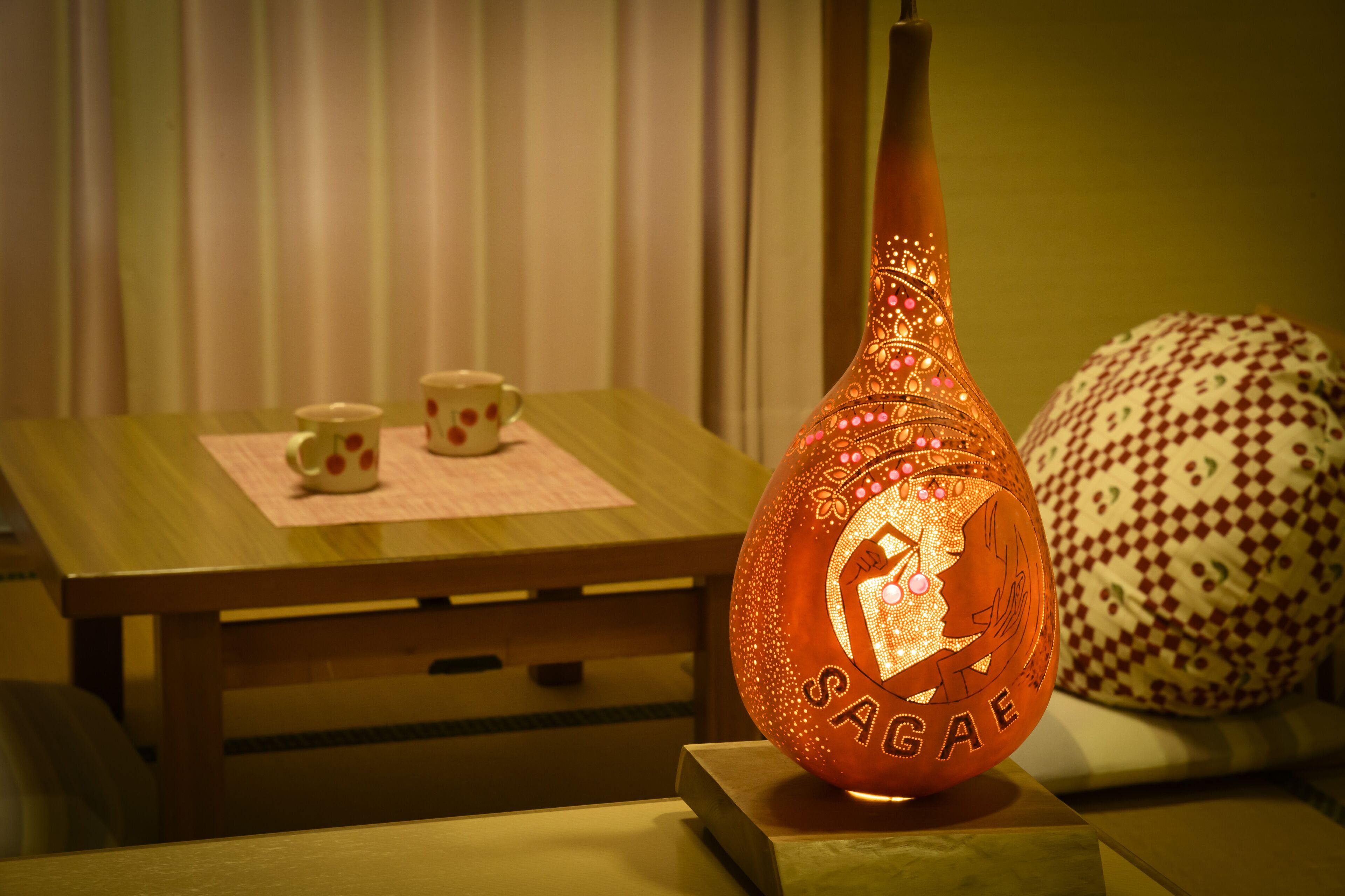 A table with a decorative vase and a patterned pillow.