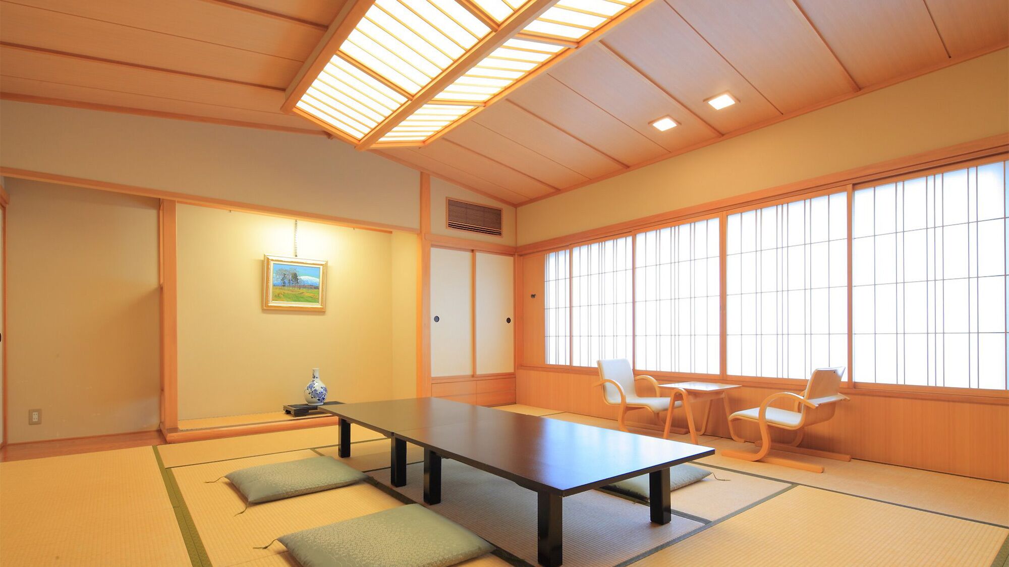 A traditional Japanese room with tatami flooring, a low table, and sliding doors.
