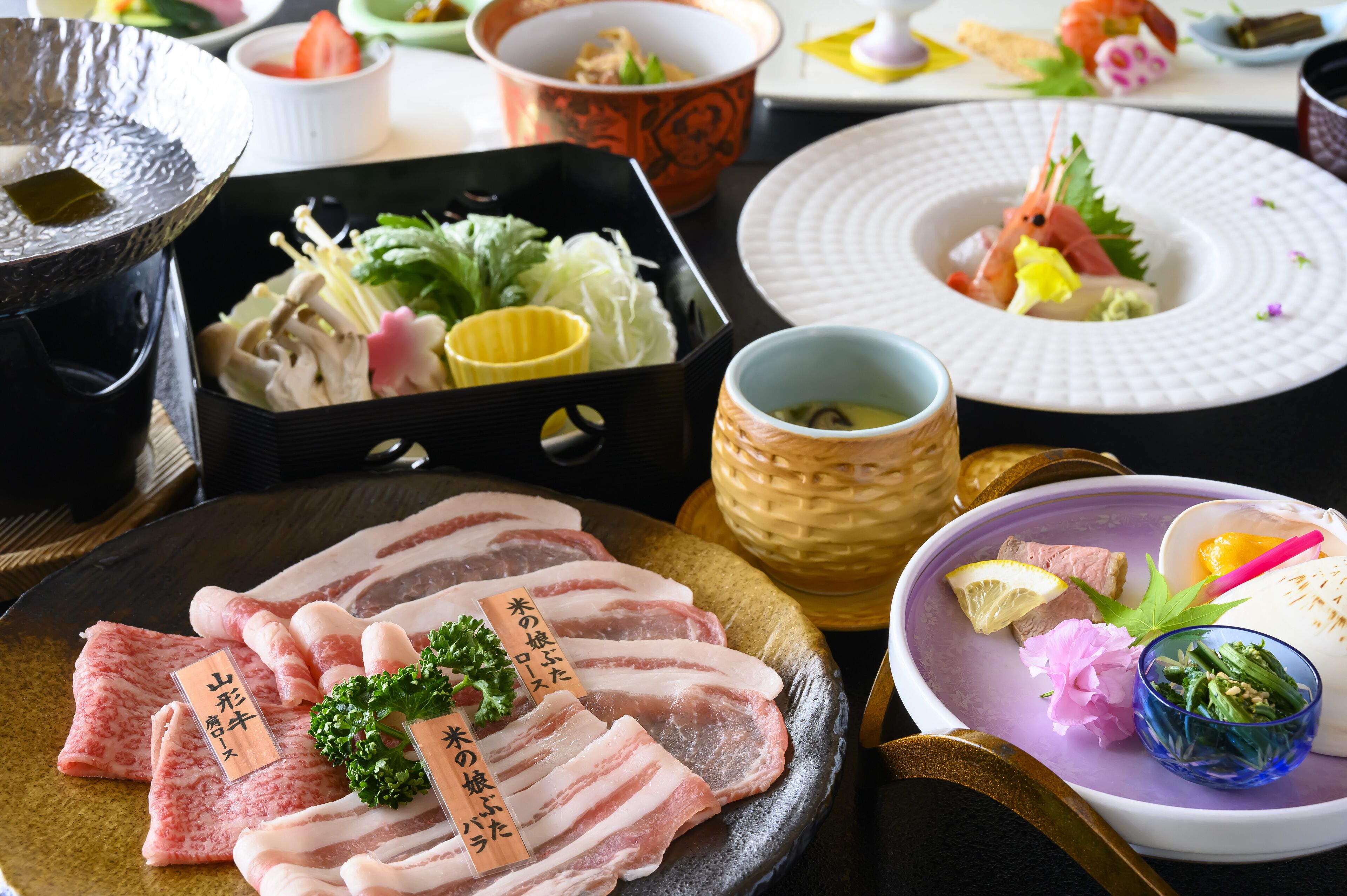 A variety of dishes including sashimi, vegetables, and a bowl of soup.