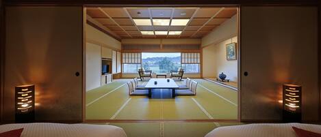A traditional Japanese room with tatami flooring, a low table, and two chairs.