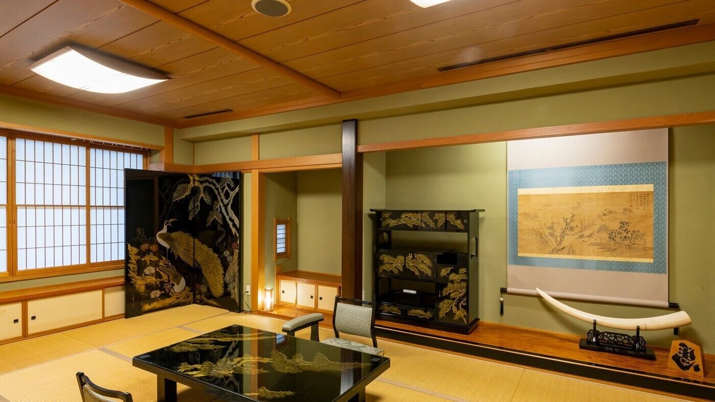 A traditional Japanese room with tatami flooring, a low table, and sliding doors.