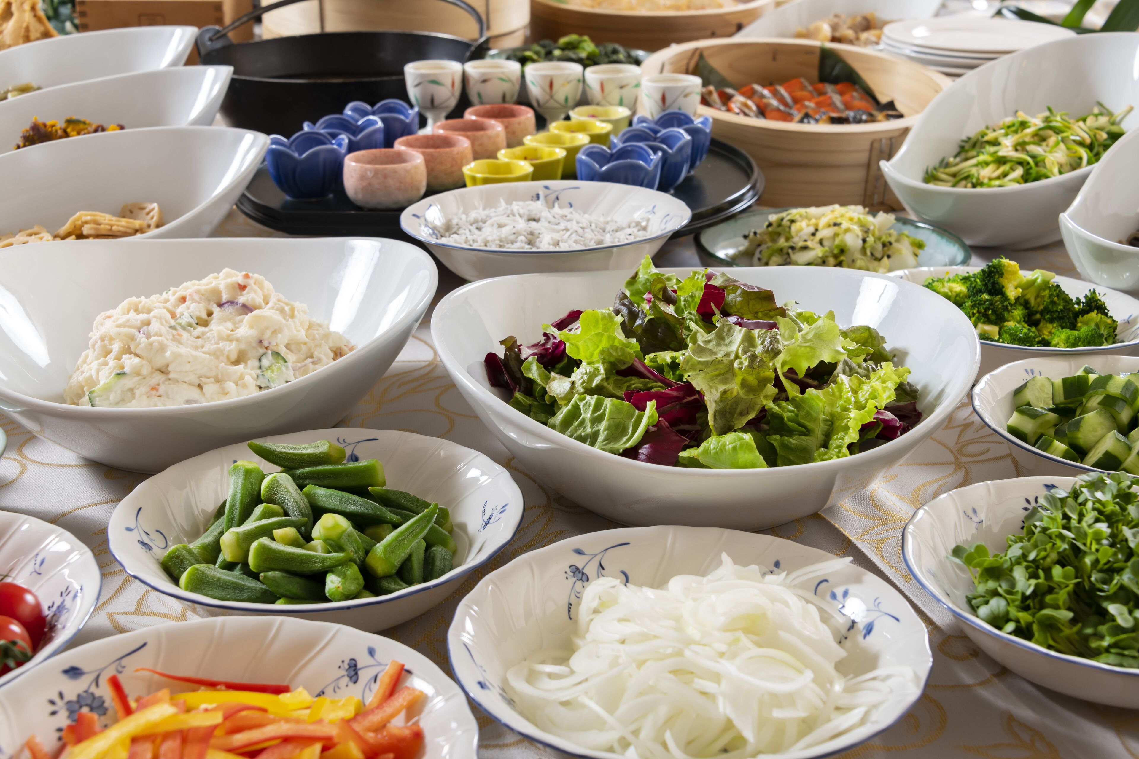 A table with various food items including bowls of rice, salads, and vegetables.