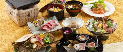 Variedad de platos japoneses dispuestos sobre una mesa con mantel estampado.