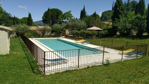 A rectangular swimming pool with a tiled deck, surrounded by a metal fence. - Lovely Mazet with shared, heated, secure swimming pool (Mirabel-aux-Baronnies)