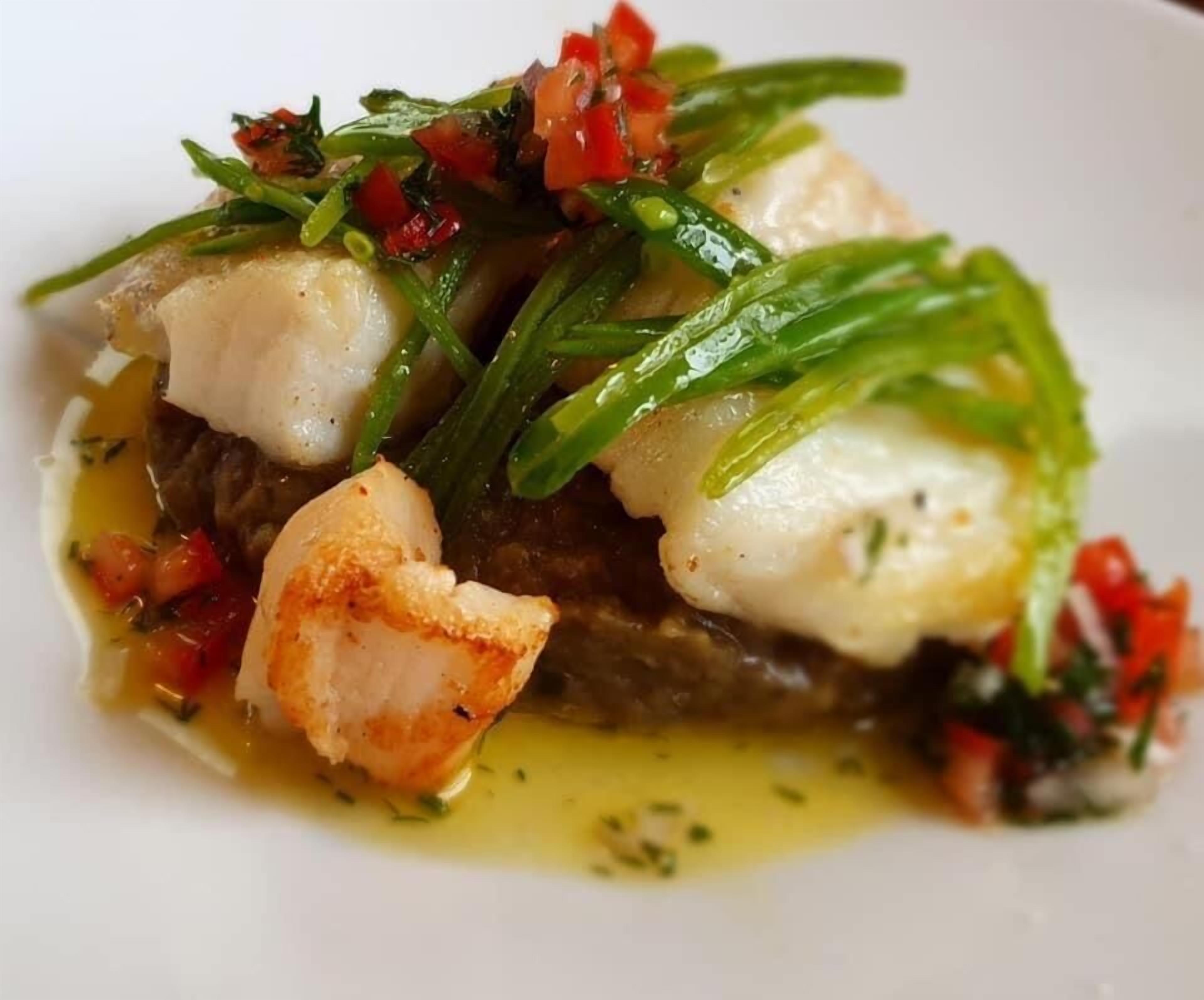 Prato com frutos do mar, possivelmente peixe, e vegetais.