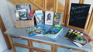 A reception desk with brochures, a welcome sign, and a wicker basket with books.