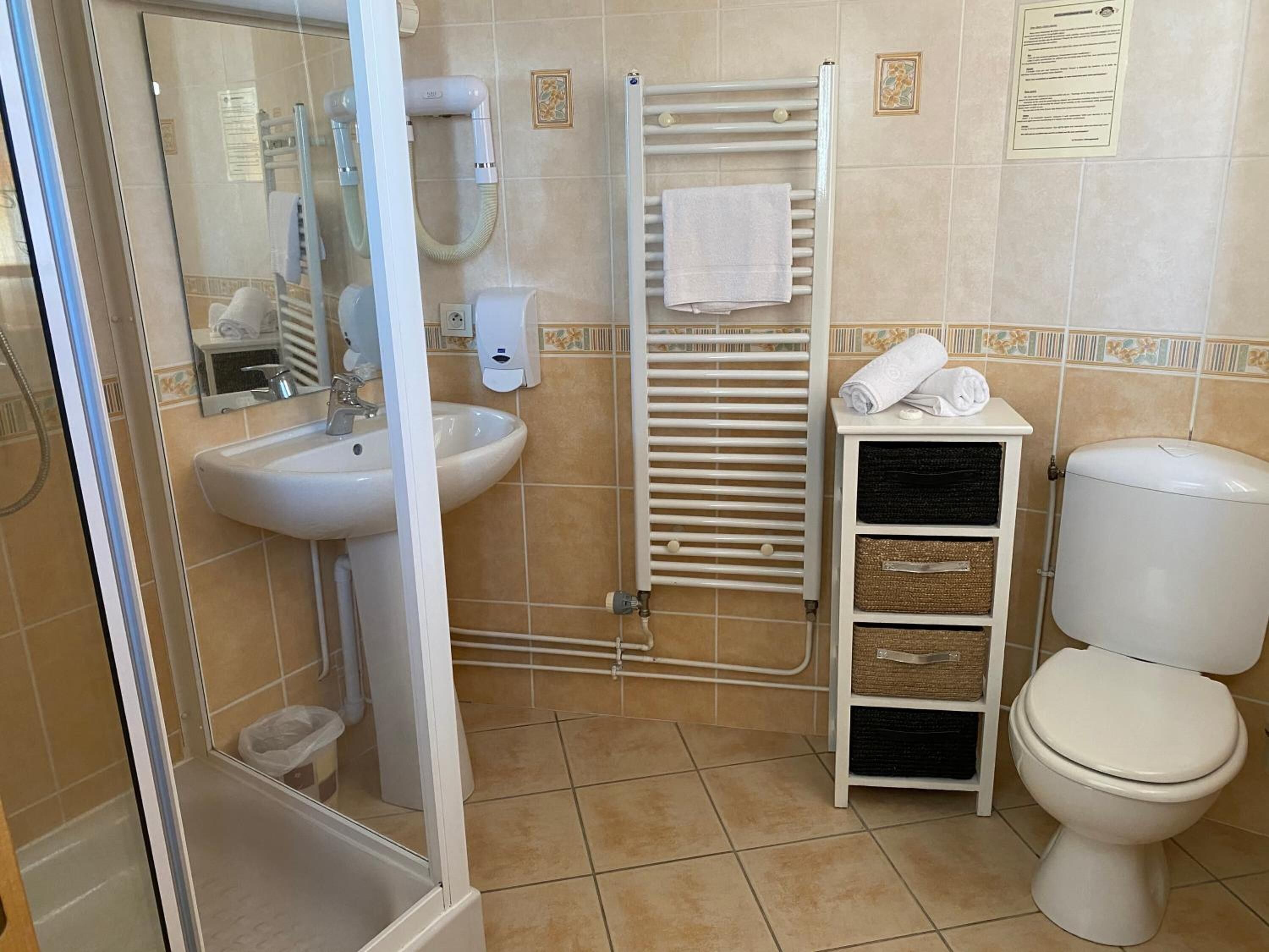 Un baño con lavamanos, inodoro y ducha.