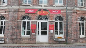 A red-brick building with a sign reading "Hotel Le Tony."