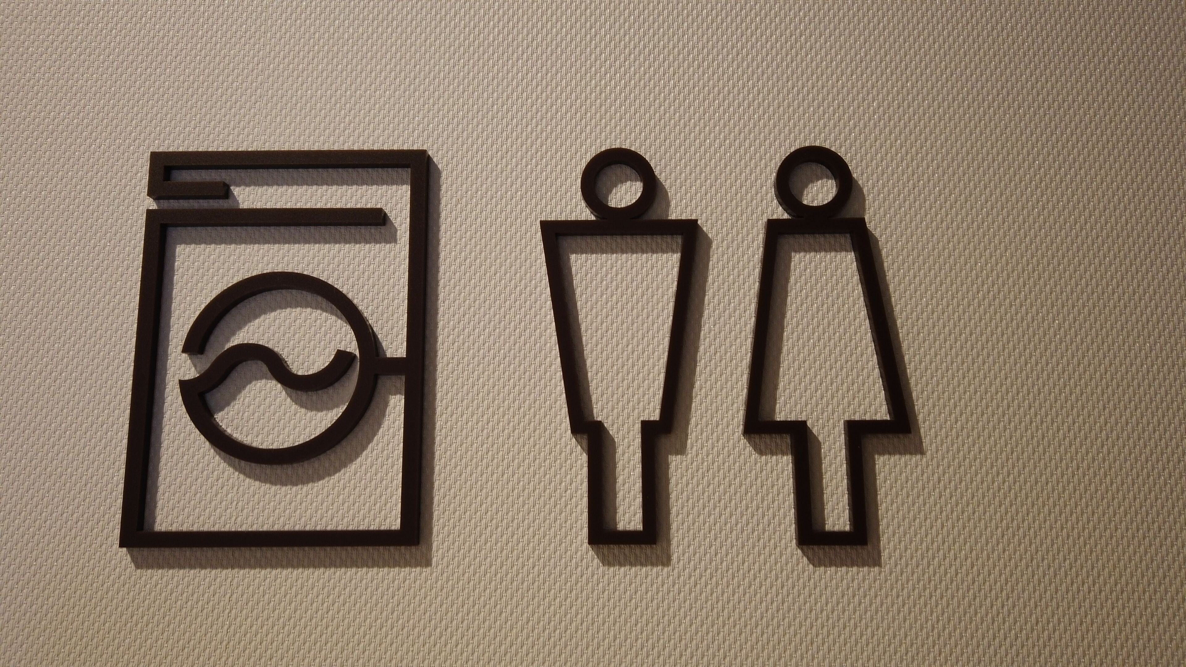 A restroom sign with a handwashing symbol and a urinal symbol.