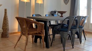 Ein Essbereich mit Tisch und Stühlen, zwei Wandlampen und einer Pendelleuchte.