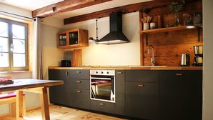 Une cuisine moderne avec des meubles en bois, un four encastré et une table à manger en bois.