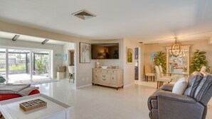 A spacious living area with a modern kitchen, a dining area, and a comfortable seating area with a sofa and chairs. - Canalfront Home w/ Dock & Pool: 5 Mi to Ft Myers! (North Fort Myers)