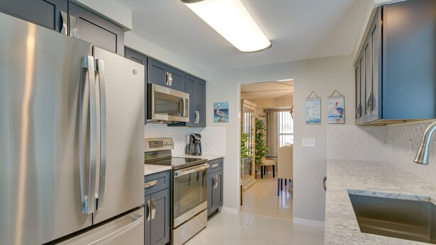 A modern kitchen with stainless steel appliances, a microwave, and a built-in oven. - Canalfront Home w/ Dock & Pool: 5 Mi to Ft Myers! (North Fort Myers)