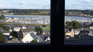 A marina with numerous boats docked, surrounded by residential buildings and a body of water. - Apartment with panoramic sea view over the bay of Perros Guirec (Perros Guirec)