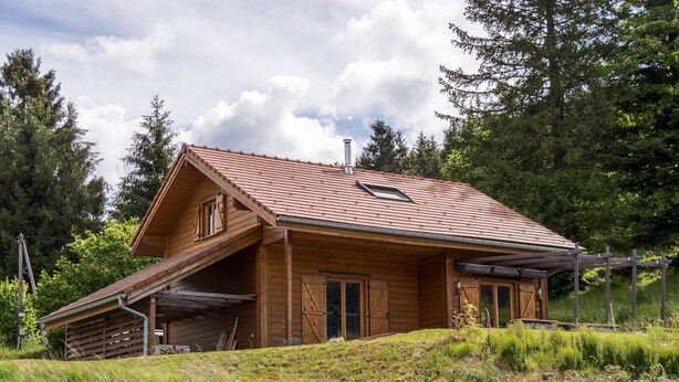 A wooden cabin with a sloped roof, a chimney, and a porch with a railing. - Chalet 6 people, Gérardmer, Les Bas-Rupts (Gérardmer)