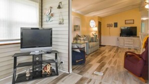 A cozy living room with a television, a sofa, and a coffee table. - Short walk to the beach * Montego Bay;Ocean City, MD (Ocean City)