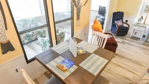 A dining area with a wooden table, chairs, and a view of the outdoors through large windows. - Short walk to the beach * Montego Bay;Ocean City, MD (Ocean City)