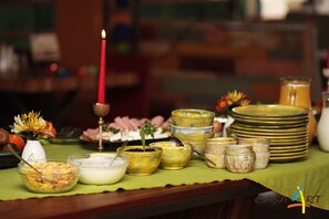 A table with various dishes, a candle, and decorative items. - Hotel Casa Art (Troyan)
