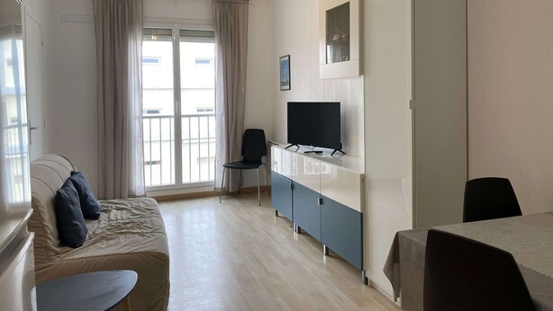 Una habitación de hotel moderna con una cama, un televisor, un escritorio y una silla.