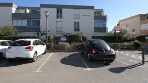 Un estacionamiento con coches, un edificio con el rótulo