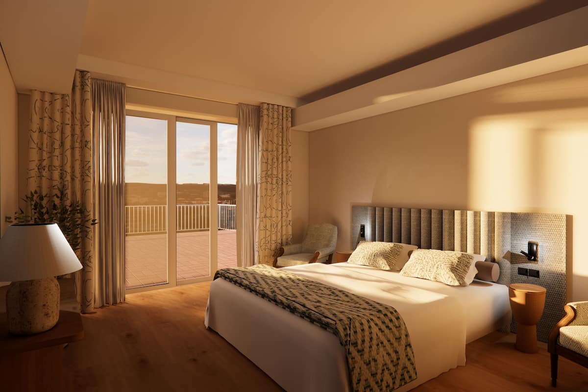 Um quarto espaçoso com uma cama grande, uma cadeira, uma mesa de cabeceira e vista para uma varanda.