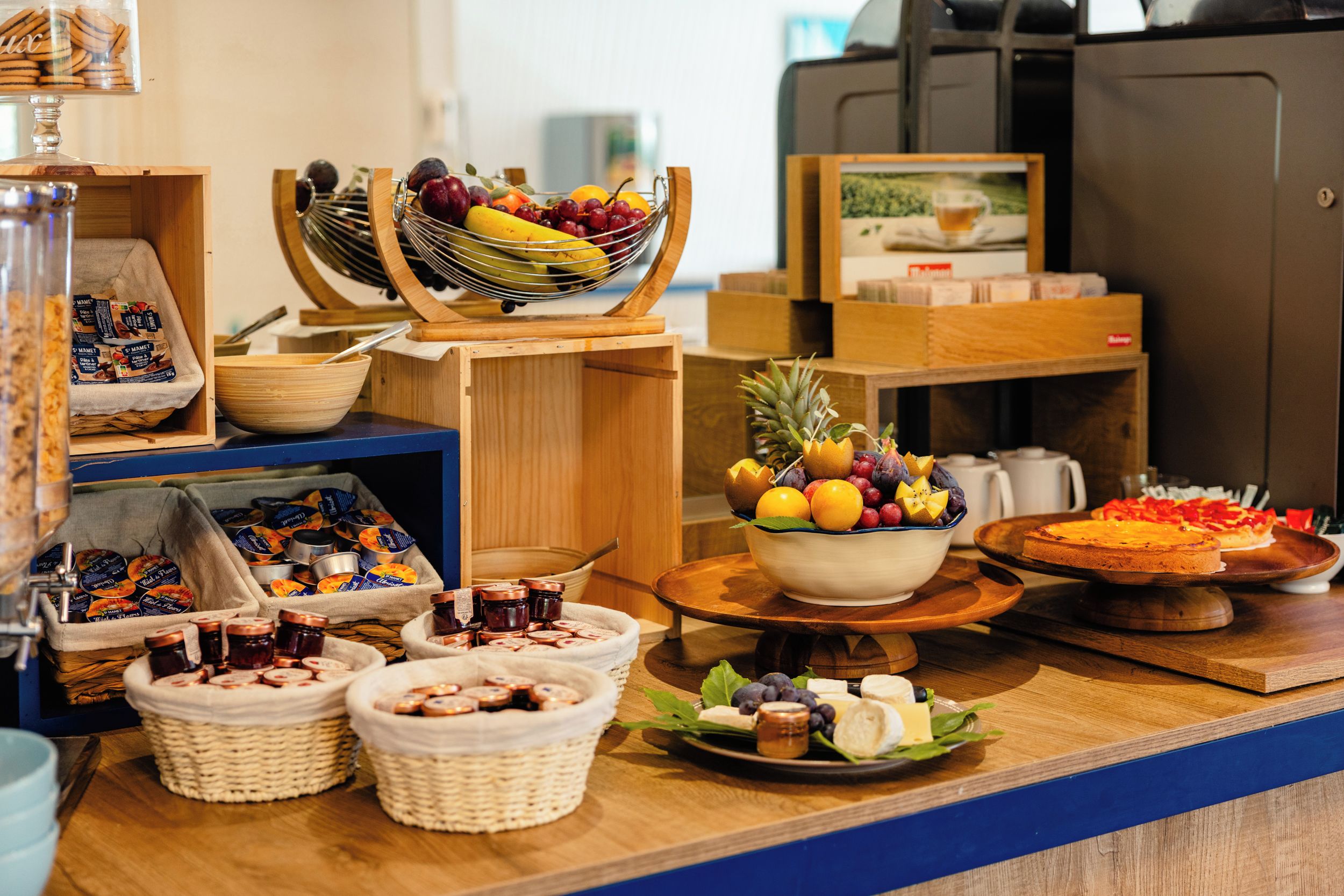 Un bufé con diversos alimentos, incluyendo frutas, quesos y pasteles.