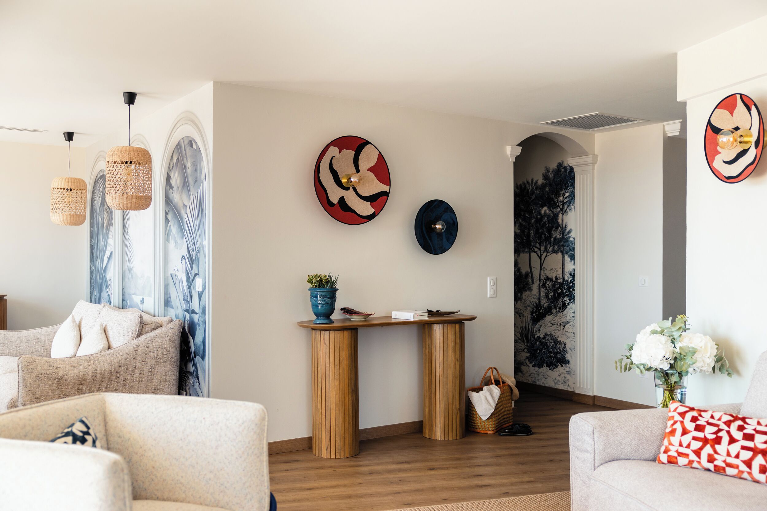 Una sala moderna con un sofá, una mesa de centro y una pared decorativa con obras de arte.