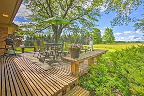 Relax on the outdoor patio with a table and chairs, surrounded by lush greenery and a potted plant.