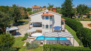 A two-story house with a swimming pool, outdoor seating, and a garden. - Villa Eufemia (Porec)