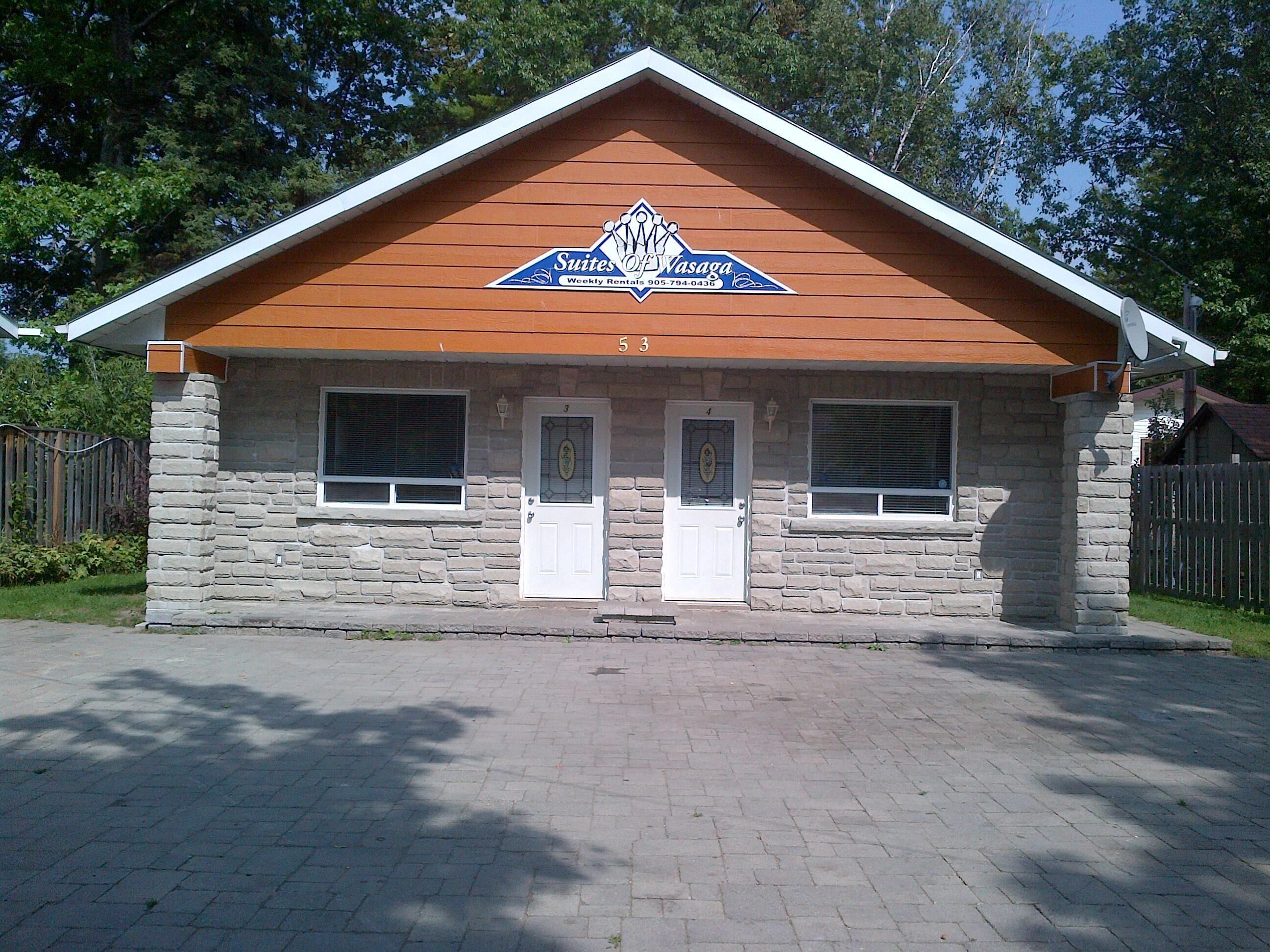 Un bâtiment à deux étages, doté d’une façade en pierre, d’un toit à pignon en bois et d’une enseigne indiquant qu’il s’agit de l’établissement « Suites of Vasaga ».
