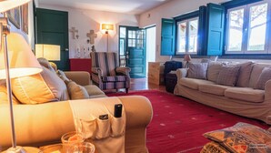 Un salon confortable avec un canapé, un fauteuil et une moquette rouge.